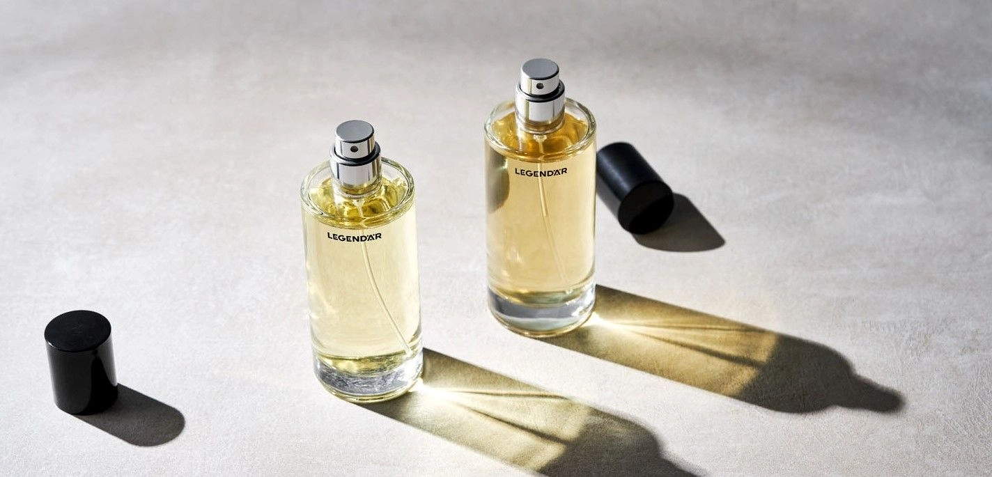 Legendär Eau de Parfum – Offene Flakons im Lichtspiel auf Betonoptik Zwei geöffnete Eau de Parfum Flakons von Legendär mit Licht- und Schattenspiel auf hellem Untergrund